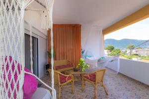 a balcony with a hammock and a table and chairs at Shark Apartments in Skala Potamias