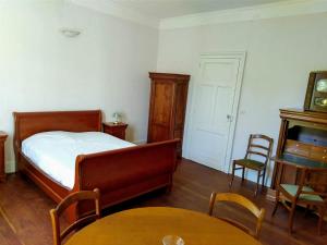 sypialnia z łóżkiem, stołem i krzesłami w obiekcie La Dilettante w mieście Malause