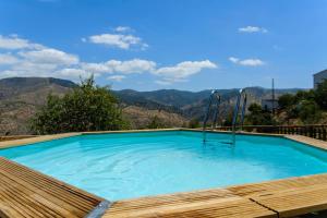 a swimming pool with mountains in the background at Complejo Rural El Mirador in Málaga
