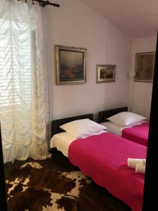 a bedroom with two beds and a window at House Carmen in Sutivan