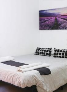 1 dormitorio con 1 cama y 2 toallas blancas en Hostal La Masia, en Manresa