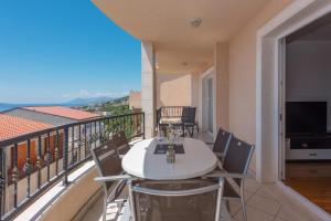 a balcony with a white table and chairs and a television at Apartments Naja - Makarska Exklusiv in Makarska