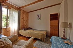 a living room with a bed and a couch at Domek Letni Bałtycka in Sopot