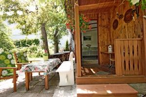a porch of a wooden house with a table and a bench at Domek Letni Bałtycka in Sopot