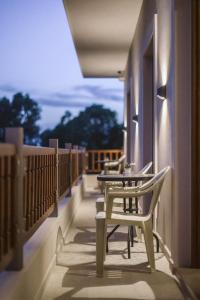 eine Reihe von Tischen und Stühlen auf einem Balkon in der Unterkunft Ale&Ana studios in Arillas