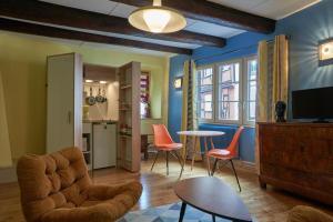 een woonkamer met oranje stoelen en een tafel bij Maison Cliquot - Appartements Colmar Centre in Colmar