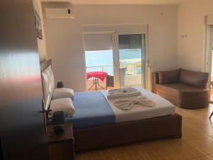 1 dormitorio con cama, sofá y ventana en Casa Mila apartments & bungalows, en Ulcinj