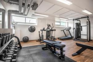 a gym with several treadmills and machines in a room at Quality Hotel Prisma in Skövde