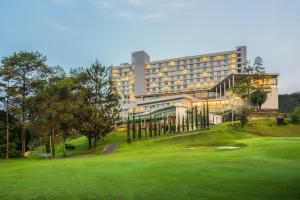 a golf course with a hotel in the background at Swiss-Belresort Dago Heritage in Bandung