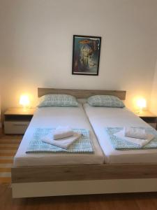 - un grand lit avec 2 serviettes dans l'établissement Apartments Veda, à Pula