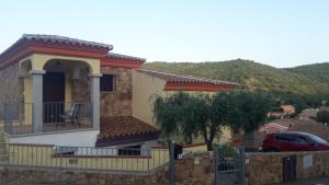 una casa con balcone e una macchina parcheggiata di fronte di Villetta Mariangela a Budoni