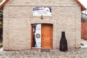 a brick building with a wooden door and a sign at Sobe na vinskoj cesti Zmajevac in Zmajevac +3 photos