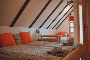 um quarto com uma cama com almofadas laranja em Sobe/Moduli na OPG-u Zajec em Zmajevac