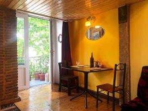 Pokój ze stołem i krzesłami oraz żółtą ścianą w obiekcie Heart of Old Tbilisi Apartments w mieście Tbilisi City
