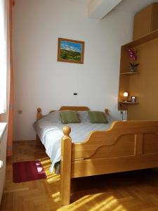 sypialnia z drewnianym łóżkiem w pokoju w obiekcie Prenociste Klas w mieście Pleternica