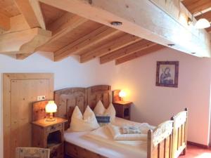 a bedroom with a large bed with two lamps on tables at Wöscherhof in Kaltenbach