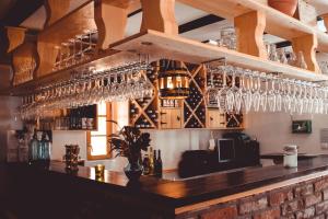 a bar with lots of wine glasses on the wall at Sobe na vinskoj cesti Zmajevac in Zmajevac