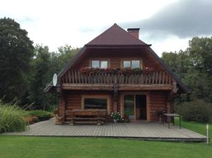 a log cabin with a porch and a deck at Kastaņas in Kaibala