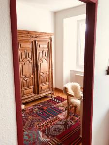 a room with a large wooden door and a chair at Appartement 1Bijou in La Chaux-de-Fonds