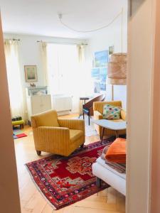 a living room with two chairs and a rug at Appartement 1Bijou in La Chaux-de-Fonds