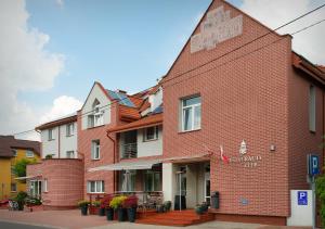 un bâtiment en briques rouges sur le côté d'une rue dans l'établissement Hotel Capitol, à Biała Podlaska