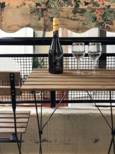 una botella de vino sentada en una mesa con dos copas en Homely Spacious Studio en Chalkida