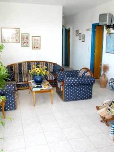 a living room with two couches and a table at Sunflower studios in Amoopi