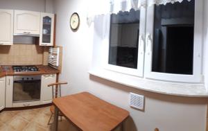 une cuisine avec des placards blancs et une table en bois dans l'établissement Apartament Jana z Kolna, à Ustka