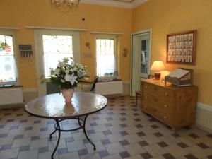 a room with a table with a vase of flowers on it at L'Étape Fagnarde - Bed, Breakfast & Sauna in Spa +40 photos