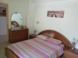 a bedroom with a bed and a dresser and a mirror at Villa Thanos in Marathias +49 photos