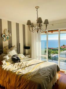 sypialnia z łóżkiem i widokiem na ocean w obiekcie VILLA FELICIDADE w mieście Arco da Calheta
