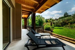 a patio with two chairs and a table on a porch at Lamasu RioVerde - Lago di Garda in San Felice del Benaco