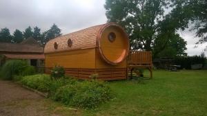 a large wooden house with a window in a yard at A la RONZIERE - Le Tonneau in Pouilly-sous-Charlieu