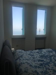 a bedroom with two windows and a bed in it at Eolo in Deiva Marina
