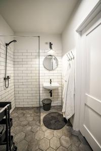 W łazience znajduje się umywalka i przeszklony prysznic. w obiekcie One Apartment w mieście Śrem