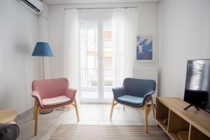 a living room with two chairs and a tv at Spacious Unique Luxurious Central in Thessaloniki