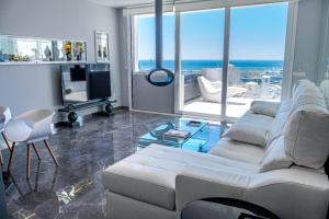 Sala de estar con sofá blanco y vistas al océano en Atico Puerto Banus, Marbella, en Marbella