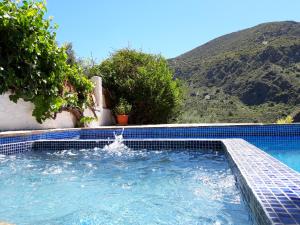 a swimming pool with a fountain in the middle at Casa Natalia in Mecina Fondales