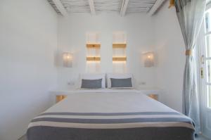 A bed or beds in a room at Yialos Ios Hotel