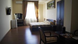 Habitación con dormitorio con cama y ventana en Hotel Ararat, en Lermontov