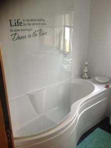 a bath tub in a bathroom with a sign on the wall at Cuil Na Sithe in Fort William