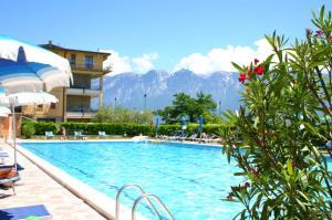 ein Pool in einem Hotel mit Bergen im Hintergrund in der Unterkunft Appartamenti Benaco La Portella by Gardadomusmea in Tignale