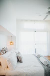 a white bed with pillows and a window at StowAway Kangaroo Island in Stokes Bay