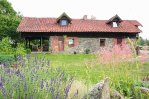a stone house with a garden in front of it at Ustronne siedlisko in Sorkwity