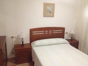 a bedroom with a bed with two nightstands and two lamps at Apartamentos Sol Andaluz in Carboneras