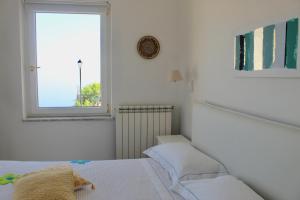 a white room with two beds and a window at Guest House Malù in Scala