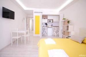 sala de estar con mesa amarilla y cocina en Charme & Chic Studios - Bari Centro, en Bari