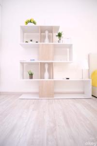 a white living room with white shelves and wood floors at Charme & Chic Studios - Bari Centro in Bari
