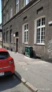 un'auto rossa parcheggiata davanti a un edificio di Apartament Ogarna 37 a Danzica