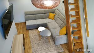 un soggiorno con un divano grigio e cuscini gialli di Apartament Ogarna 37 a Danzica